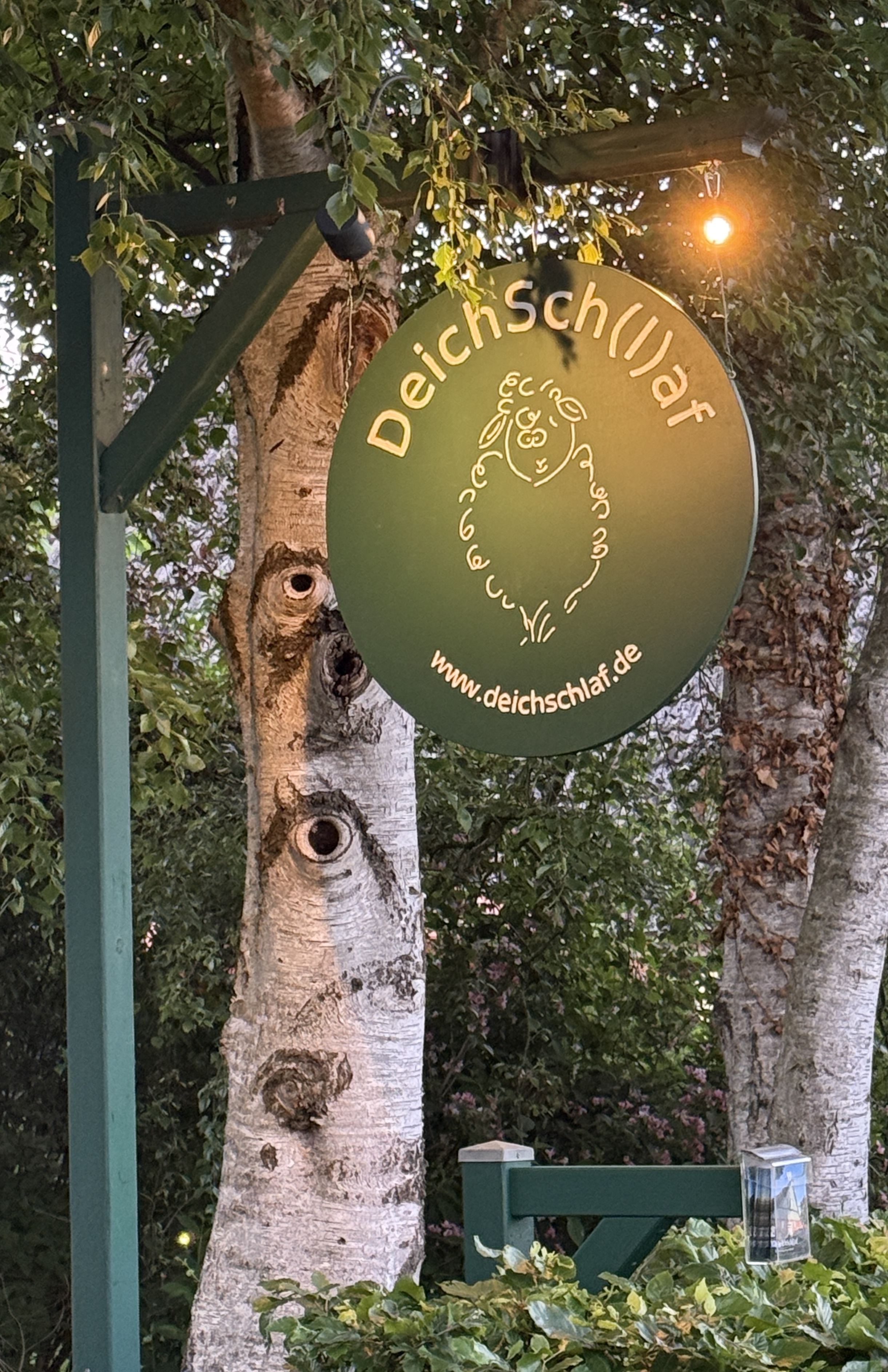 The handcrafted DeichSch(l)af sign at dusk
